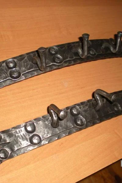 masywne metalowe wieszaki ścienne z dekoracyjnymi ćwiekami, luksusowe akcesoria do przedpokoju w stylu toksańskim. 