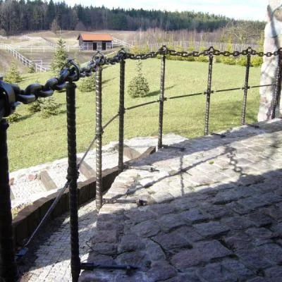Ażurowa barierka tarasowa o fakturowanej strukturze, wykonana z masywnego łańcucha okrętowego i stalowych słupków,  idealna na kamienne podmurówki. 