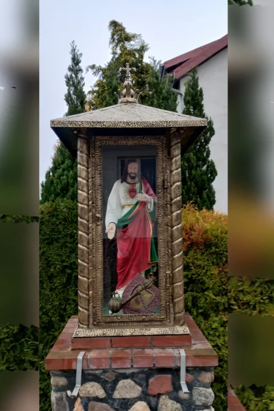 Wolnostojąca kapliczka przydrożna  o strukturze gabloty. Zamykana metalowa architektura sakralna dedykowana do bezpiecznej ekspozycji figur świętych.